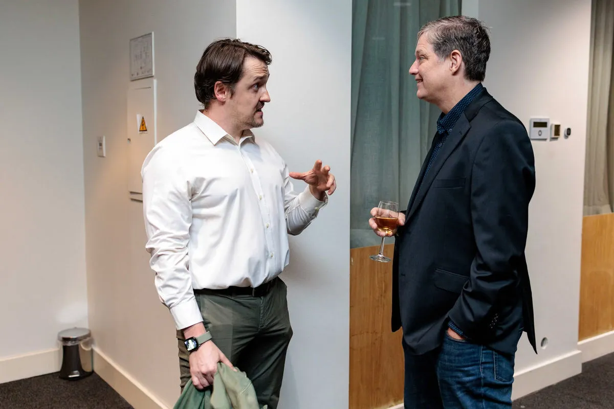 Vasilii mid-conversation with a guest at an event, gesturing as they talk.